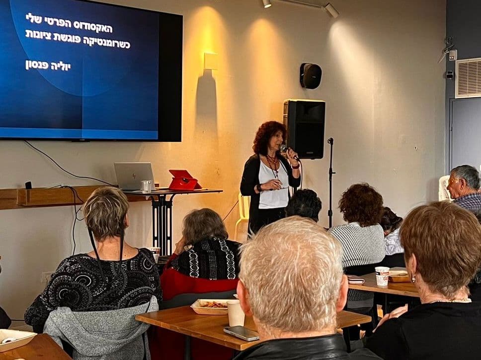 יוליה מרצה בפני קהל בבית קפה